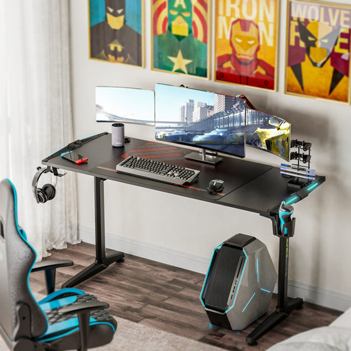 GIP RGB Gaming Desk in a typical gamer's room setting with gaming peripherals on top.