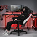 Red Warzone Gaming Chair in a realistic red-backlit gaming room with a man sitting reclined on the chair.