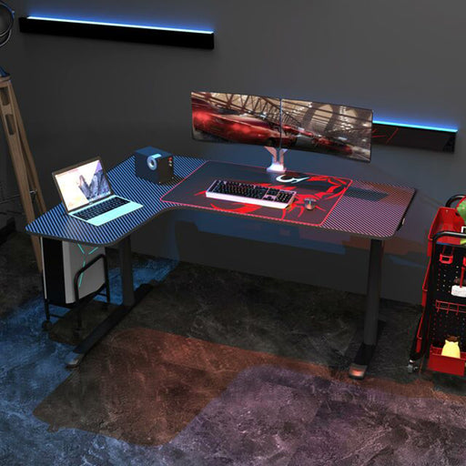 Black L-Shape Desk in a simple room setting with a few peripherals on it.