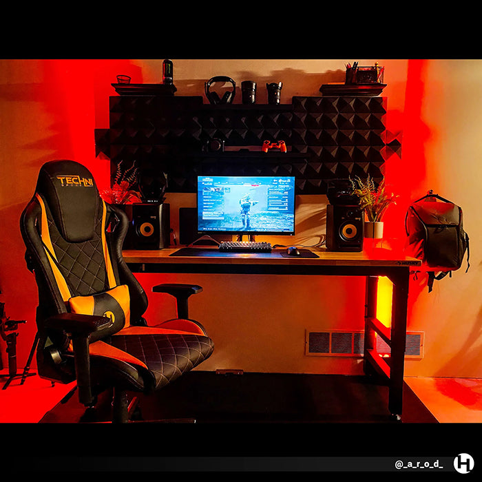 The TS-84 Ergonomic High Back Racer Style PC Gaming Chair in front of a heavily-orange-themed PC Gaming Set-up.